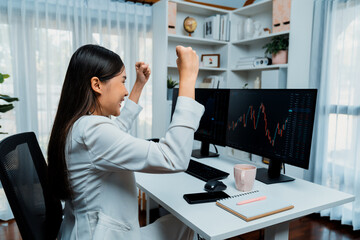 Successful young Asian businesswoman earning highest profit with fist up in exchange stock market...