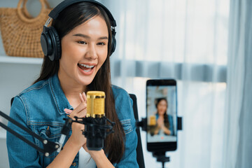 Host channel Asian influencer talking in broadcast wearing headsets on social media live on...