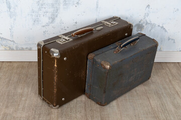 Vintage old classic travel leather suitcases circa 1940-60s. Travel luggage concept. Retro suitcases on a white wall background.