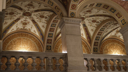 Intricate and ornate ceiling arches in a historic building, featuring detailed gold and blue decorations.