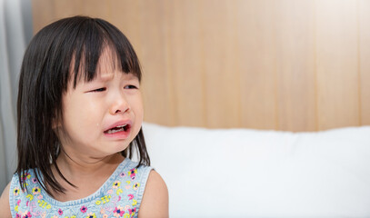 Portrait of little asian crying girl little rolling tears drop cheek weeping emotion hurt pain. Young asian toddler girl in terrible two. Back to school education concept