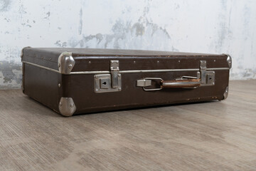 Vintage old classic travel leather suitcase circa 1940-60s. Travel luggage concept. Retro suitcase on a white wall background.