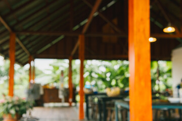 Cozy Restaurant Interior with Rustic Wooden Beams and Natural Greenery Surrounding the Dining Area
