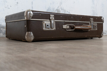 Vintage old classic travel leather suitcase circa 1940-60s. Travel luggage concept. Retro suitcase on a white wall background.
