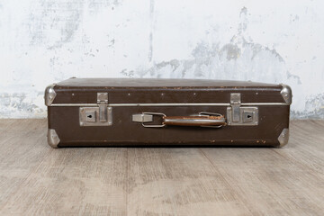 Vintage old classic travel leather suitcase circa 1940-60s. Travel luggage concept. Retro suitcase on a white wall background.