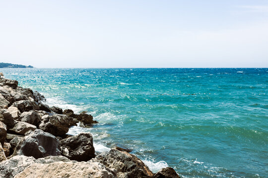 Rocky Coastline with Turquoise Ocean Waves and Clear Sky 