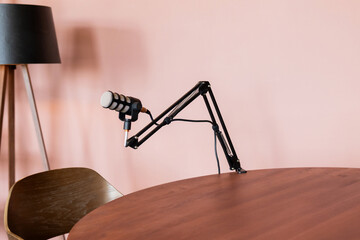 Podcast setup with a microphone on a wooden table in a modern studio environment