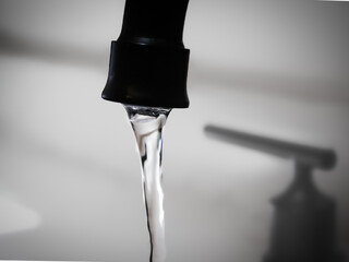 close-up of water flowing from a faucet. abstract theme design element. concept of resources,...