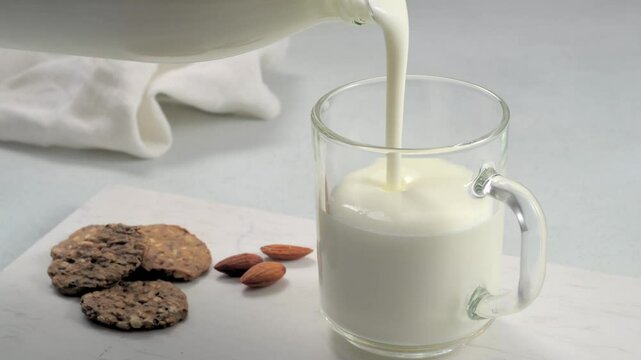 Pouring kefir and whole grain bread and almonds.