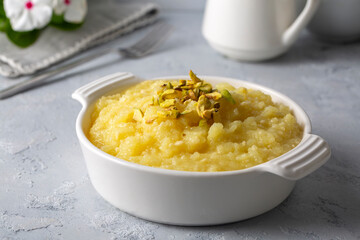 Sweet yellow Turkish dessert cheese halva Hosmerim on the white plate in the kitchen.
