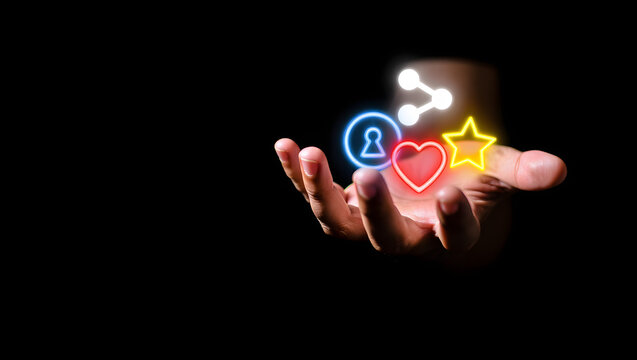Hand Holding Glowing Neon Social Media Icons:  Love, Share, Star, Profile; Dark Background; Abstract Concept.