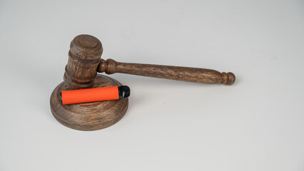 Judge's gavel and e-cigarette. Smoking ban. Tobacco heating systems. 