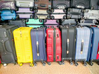 Colorful collection of various suitcases stacked together, showcasing different sizes and designs, perfect for travel enthusiasts and showcasing luggage options for journeys