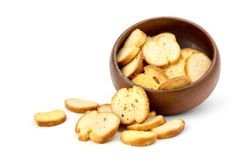 Bruschetta slices arranged in a wooden bowl, with some pieces scattered around, showcasing a...