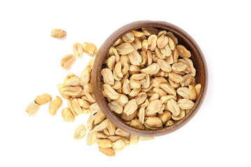 Roasted salted peanuts in a wooden bowl, scattered on a white background, showcasing their crunchy texture and natural color, ideal for snacking and culinary uses