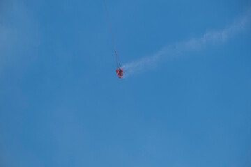 Dab bucket filled with water carried by a firefighting helicopter