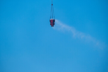 Dab bucket filled with water carried by a firefighting helicopter