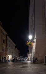 Quiet streets of Ljubljana Old Town at night with lamps and flowers