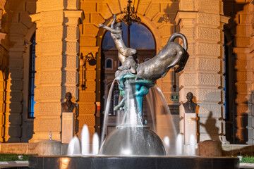 Modern fountain sculpture in front of University of Ljubljana at night