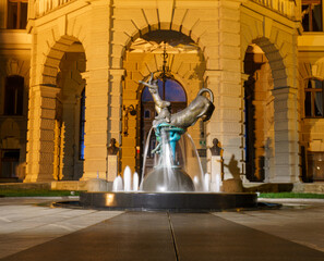 Modern fountain sculpture in front of University of Ljubljana at night