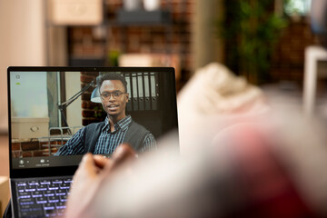 Remote worker speaks with company manager on video call, discussing tasks and responsibilities of...