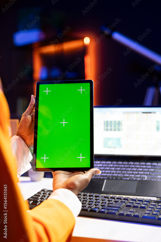 Poster self employed person at home checks statistics on laptop while using chroma key tablet. remote worke