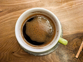 top view of a Green Coffee Cup on Wooden Cafe Table