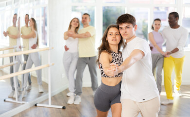 Woman in sports clothes learn to dance couples latin dance, energetic and fast tango in modern...