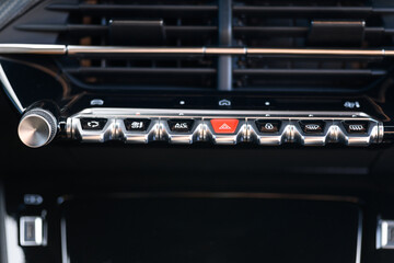 Close-up photo of the control panel with climate and hazard buttons on a modern car