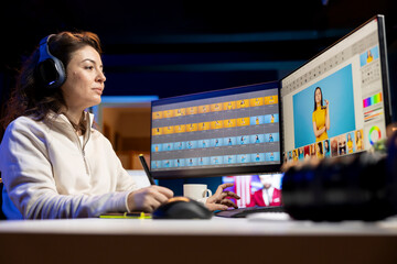 Photographer using advanced photo editing software and listening podcasts. Photo editor utilizing...