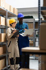 Diverse employees team in safety gear perform shipment tasks in the depot, managing bar code...