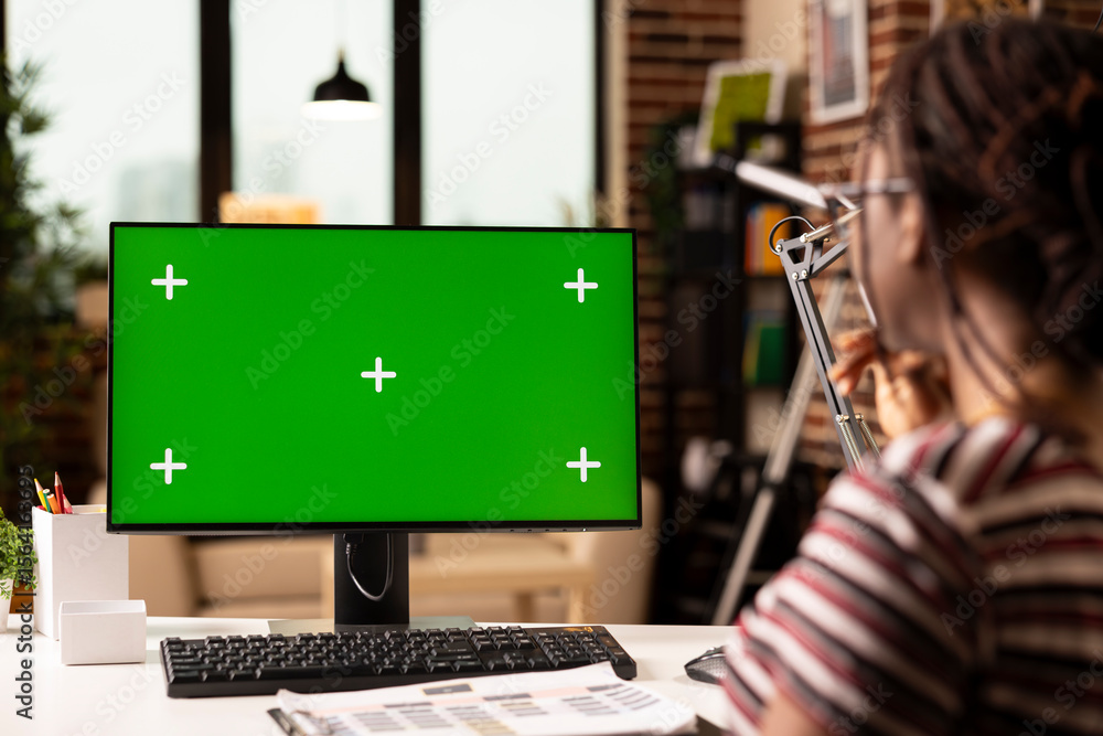 Poster freelancer works from home using computer with green screen, reviewing template for editing or prese