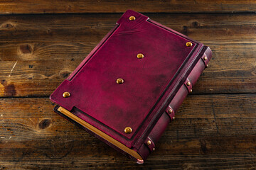 old purple leather book with metal corners on wooden background