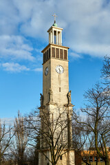classicist campanile with statues of saints and a clock of a catholic church in the city of Poznan