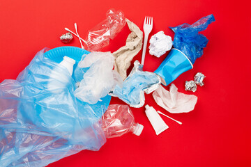 Bag with unsorted waste on color background, top view