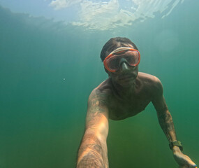 Diving in Lake Levico, in Trentino, northern Italy, for a tourist of forty years. The man is of...