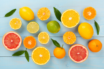 Different citrus fruits on wooden background, top view