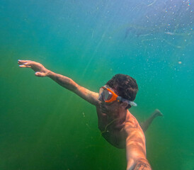 Tourist swims underwater during an apnea dive in the lake of Levico in Trentino, Northern Italy....
