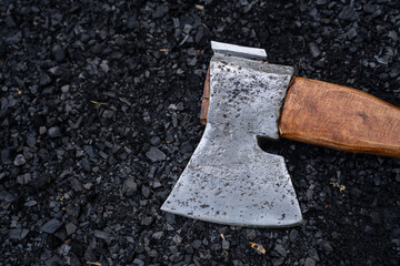   metal axe lies on the charcoal.