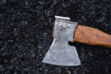   metal axe lies on the charcoal.