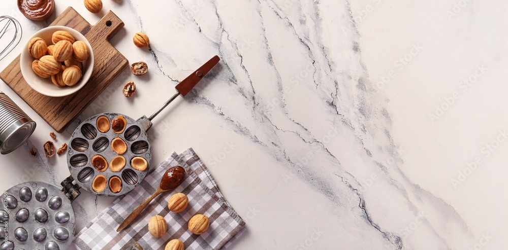 Wall mural composition with tasty walnut shaped cookies, boiled condensed milk and baking form on light backgro