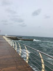 Calm sea under overcast sky viewed from pier