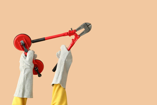 Female worker with tools on beige background