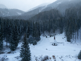 winter landscape in the mountains in austria drone view and cute chapel in snow