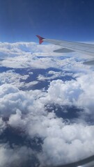 Vista desde una ventana de avión, del cielo azul y nubes blancas en un día soleado
