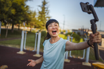 Japanese woman blogger record video for v-log and show outdoor gym