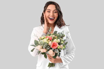 Beautiful bride with wedding bouquet on light background