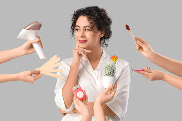 Happy African-American woman and hands suggesting different methods of epilation on grey background