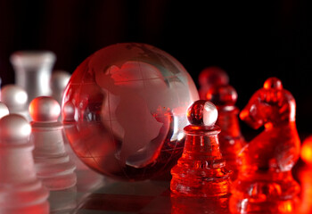 Crystal planet Earth amidst chess pieces showing the American continent, representing concepts of geopolitics, global power, competition for control, international relations, world leaders, struggle f