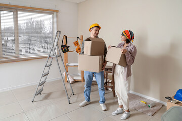 Young couple with boxes during repair in their new house